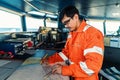 Filipino deck Officer on bridge of vessel or ship. He is plotting position on chart