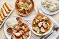 Filipino dinner with sinigang, lechon kawali, and chicken adobo Royalty Free Stock Photo