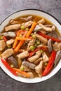 Filipino food Igado is a popular Ilocano dish made from pork tenderloin and innards with vegetables closeup in the plate. Vertical Royalty Free Stock Photo