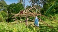 Filipino men building a simple house on a jungle hillside in the Philippines.