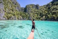 Filippino boy steering boat in shallow lagoon