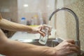 Fill a drinking glass with tap water Royalty Free Stock Photo