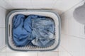 Filled basket clothes. Dirty laundry. Bathroom floor. Top view.