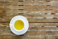 Filled Cup of tea on a ceramic dish on wooden table Royalty Free Stock Photo