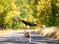 Filled with energy. A young woman doing a cartwheel in the middle of the road. Royalty Free Stock Photo