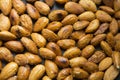 Filled frame background wallpaper shot of a bunch of crunchy roasted almonds with sea salt on a black background