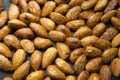 Filled frame background wallpaper shot of a bunch of crunchy roasted almonds with sea salt on a black background