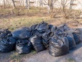 Filled with garbage black plastic bags on the street, garbage collection concept, street cleaning Royalty Free Stock Photo