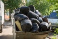 Filled with garbage black plastic bags on the street, garbage collection concept, street cleaning, waste Royalty Free Stock Photo