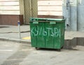 Filled green trash container on a city street closeup