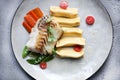 Fillet of cod with dumplings, carrots, green sweet pea and tomatoes at vegetarian restaurant