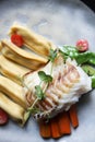 Fillet of cod with dumplings, carrots, green sweet pea and tomatoes at vegetarian restaurant