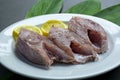 Fresh raw fish on white plate with green leaf and lemon Royalty Free Stock Photo