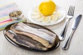 Fillet of herring, lemon, boiled eggs, condiment, knife and fork Royalty Free Stock Photo