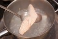 A fillet of salmon being poached on a stove