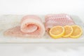 Fillet of sea bass and slices of pink lemon close up on a marble cutting board on white background