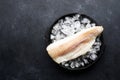 Fillet of white sea cold-water fish cod in ice cubes on a dark background. Top view Royalty Free Stock Photo