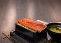 Fillets of japanese unagi eel grilled in a kabayaki style with a cup of misoshiru soup and chopsticks. Royalty Free Stock Photo