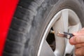 Filling air into a grungy car tire to increase pressure Royalty Free Stock Photo