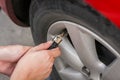 Filling air into a grungy car tire to increase pressure Royalty Free Stock Photo