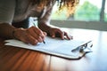 Filling in all her details. Closeup shot of an unrecognizable woman filling in paperwork at a table. Royalty Free Stock Photo