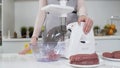 Making minced meat in electric meat grinder from fresh beef at home. Pile of chopped meat. Electric mincer machine with