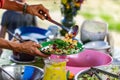 Filling a dish with fruit and Nuts salad