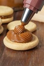 Filling with dulce de leche an Argentinian alfajor made with cornstarch Royalty Free Stock Photo