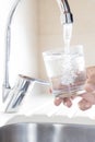 Filling glass of water in hand from kitchen faucet