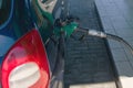 Filling gun into the hole of empty gasoline tank of car on diesel fueling. Filling station concept Royalty Free Stock Photo