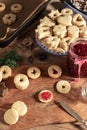 Filling Linzer Christmas cookies with red currant jam
