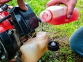 Filling the tank of a petrol-powered lawn mower. Royalty Free Stock Photo