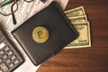 Filling the tax forms with bitcoin crypto currency coin money, black leather wallet with dollars and calculator on a Royalty Free Stock Photo