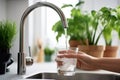 Filling up a glass with clean drinking water from kitchen faucet. Safe to drink tap water