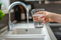 Filling up a glass with clean drinking water from kitchen faucet. Safe to drink tap water Royalty Free Stock Photo
