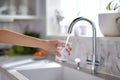 Filling up a glass with clean drinking water from kitchen faucet. Safe to drink tap water Royalty Free Stock Photo