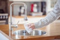 Filling up a glass with drinking water from kitchen tap Royalty Free Stock Photo