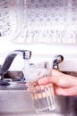 Filling water glass at faucet Royalty Free Stock Photo