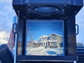 Film is back. Looking through the view finder of a medium format film camera. Houses in the view. Winter. Film photography.