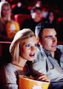 Film, cinema and couple love popcorn at the movie theatre at night in a dark room for horror, action and scary