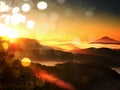 Film effect.Autumn sunrise above above forest, fall colorful valley full of dense mist colored with hot sun rays. Foggy strips