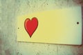 Film effect, film grain. a small white plaque on the wall of pressed plywood. a beautiful red heart with black edging, Billboard