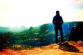 Film grain. Alone young girl tourist feast daybreak on the sharp corner of sandstone rock and watch over valley to Sun. Royalty Free Stock Photo