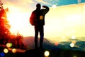 Film grain. Silhouette of tourist. Sunny spring daybreak in rocky mountains. Hiker with sporty backpack stand on rocky view point