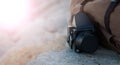 The film medium format camera lies on the stones against the backdrop of a canvas vintage backpack. In the sun
