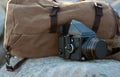 The film medium format camera is on the rocks next to the backpack