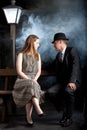 Film noir couple street lantern bench fog mist Royalty Free Stock Photo