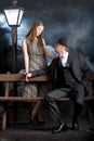 Film noir couple street lantern bench fog mist Royalty Free Stock Photo