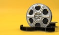 Film reel isolated on bright yellow background in pastel colors. Minimalist creative concept. Cinema, movie, entertainment concept Royalty Free Stock Photo