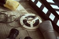 Film reel, movie clapperboard, two microphones and an old movie camera with two lenses on a table with a gray Royalty Free Stock Photo